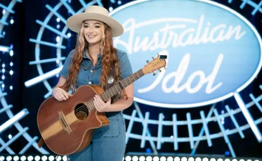 Singer Keely Ellen, wearing a hat and holding a guitar, auditions for Australian Idol