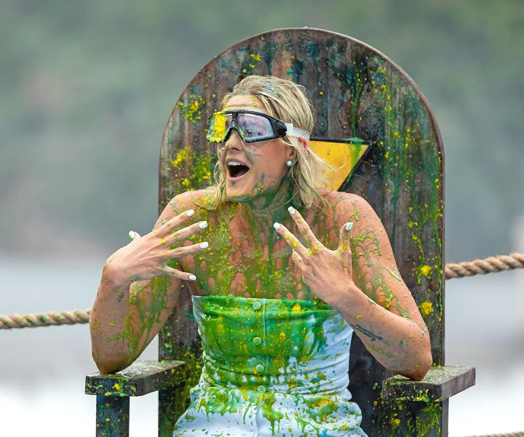 Shayna sits in a blue outfit covered in green slime while wearing goggles in a chair in a challenge on I'm a Celebrity... Get Me Out of Here!