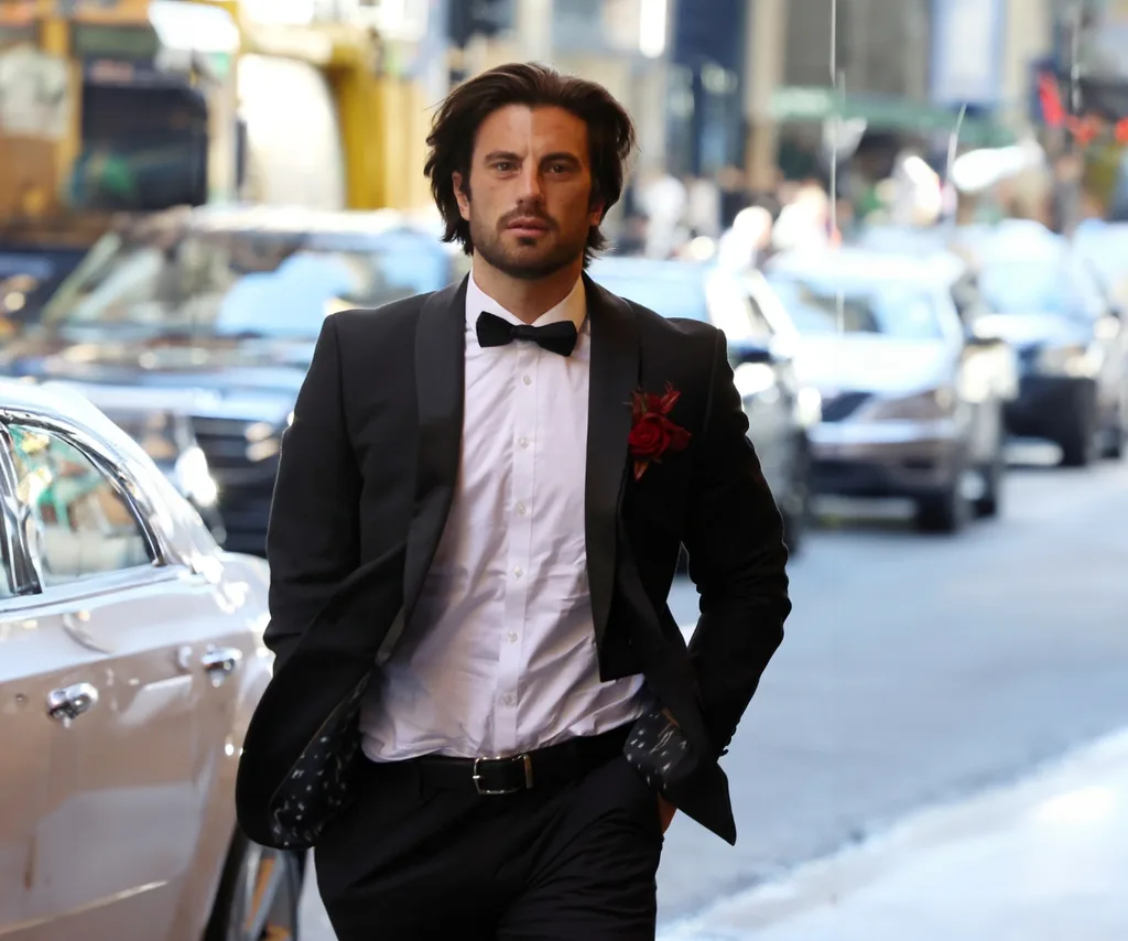 A suited up Eliot is seen walking into the wedding venue on his wedding day.