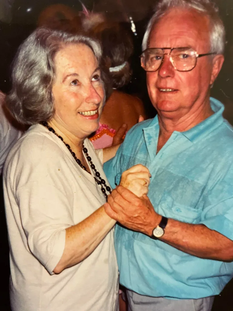 A younger Joan, wearing white, dancing with her husband