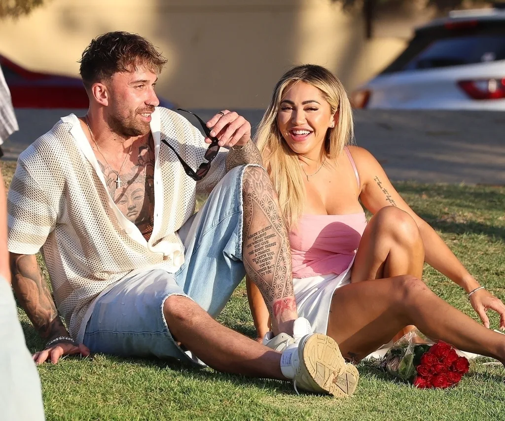 Billy and Awhina sit on a grassy knoll in Perth