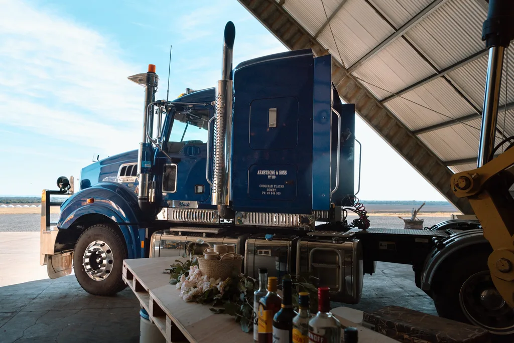 A massive truck cabin in a shed with a wedding table with bottles of spirits