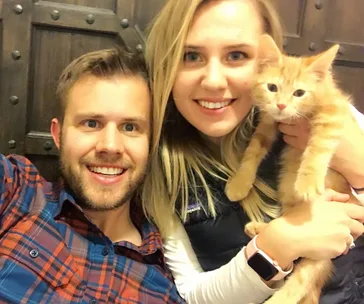 Colin and I holding our ginger cat Phineas. (Image: Supplied)