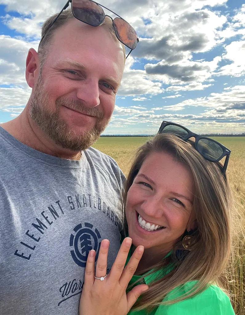 Hollie holding up her engagement ring with Jono on the farm
