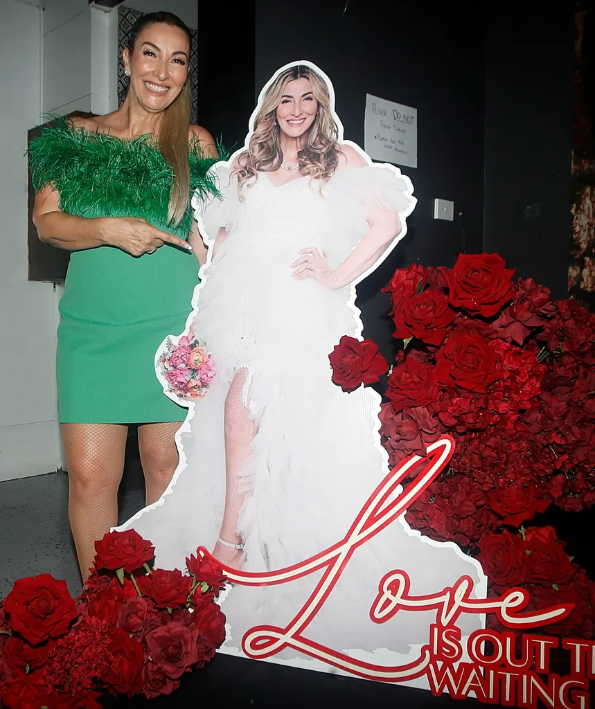 Morena stands in green dress next to a cardboard cutout of herself.