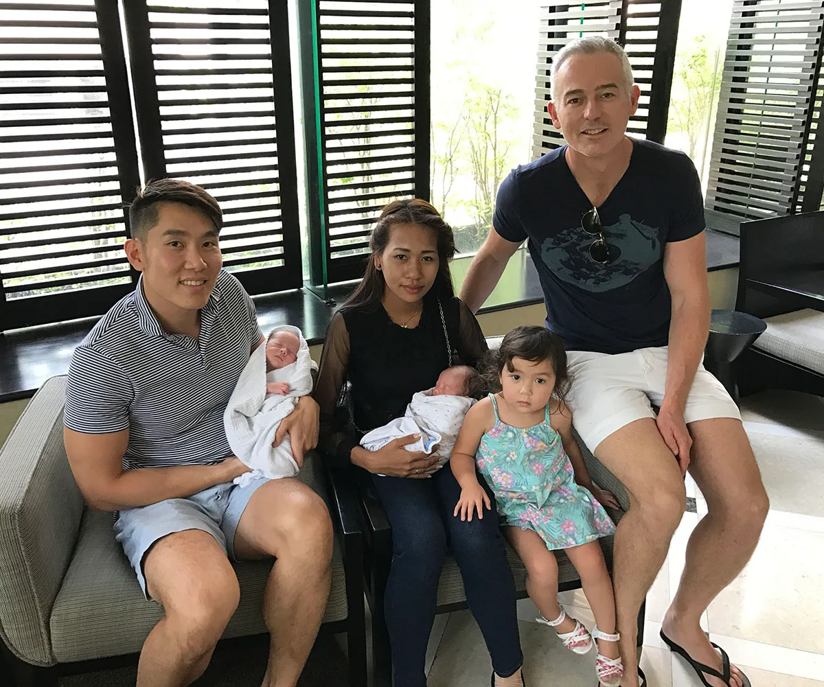 Joseph and I with our kids - Celeste, Julian and Iris with our surrogate. (Image: Supplied)