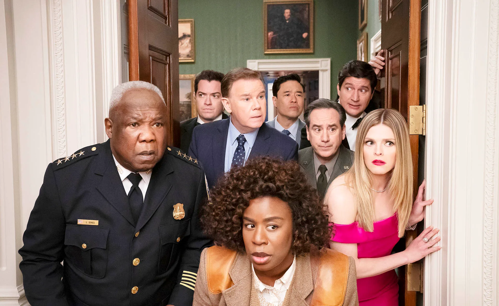 Uzo Aduba, as Cordelia Cupp, stands in front of other cast members, inside the White House, all looking alarmed.
