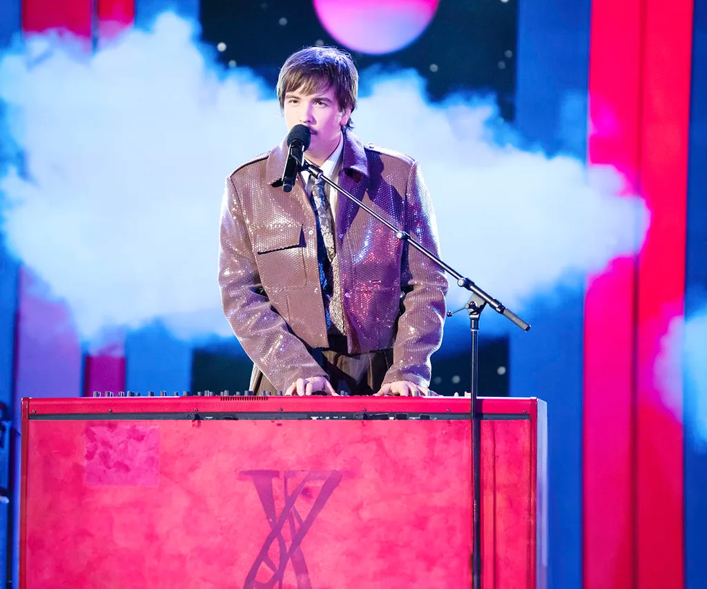 Marshall Hamburger performing on stage with a cloud of smoke behind him, playing piano.