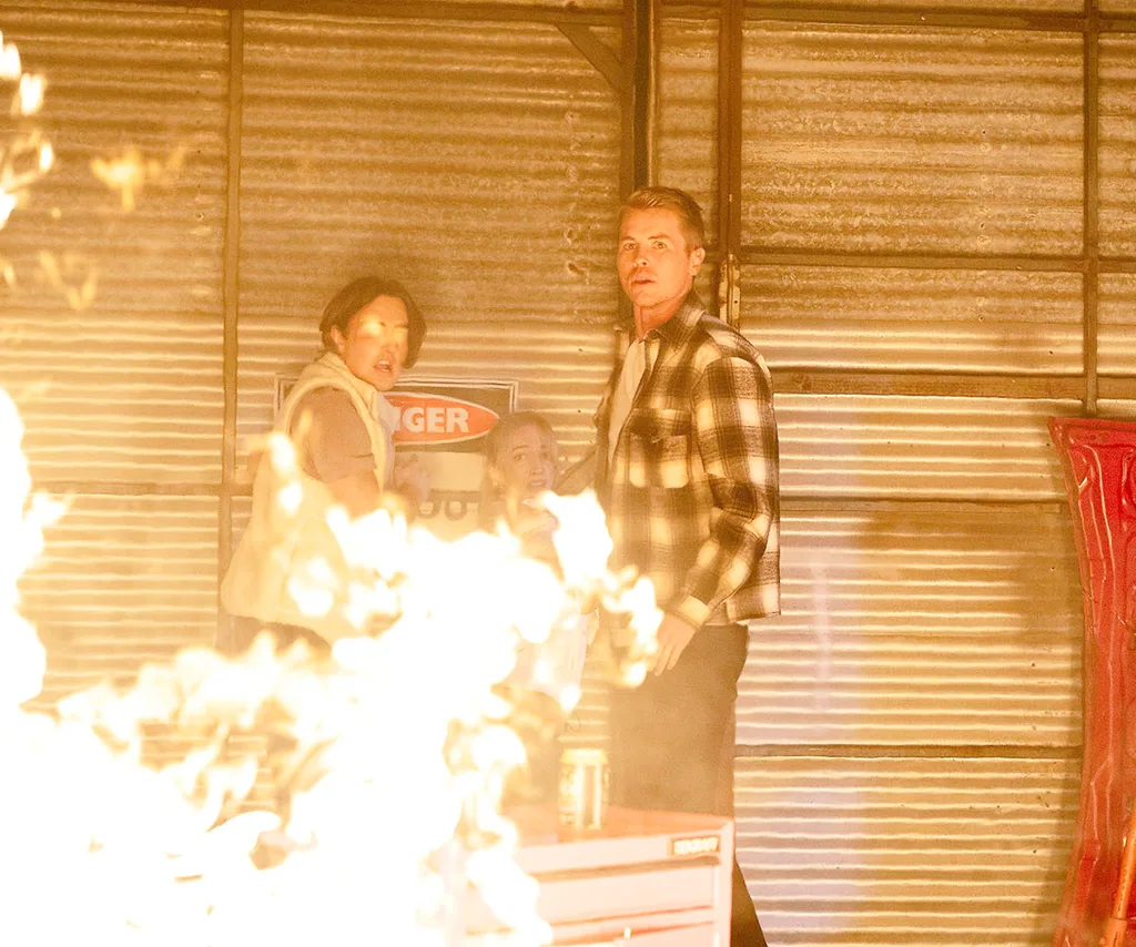 Max, Roxy and Byron stand amidst the flames with the warehouse walls in the background