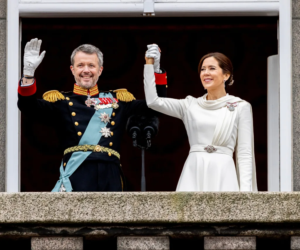 king fred and queen mary waving from a balcony