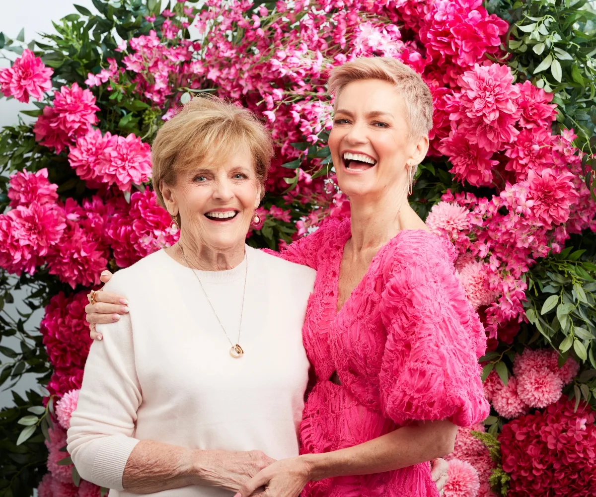 Jess Rowe and her mother Penelope pose in front of a rose bush