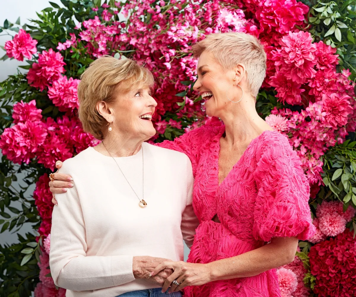 Penelope and Jess pose together in front of a rose bush