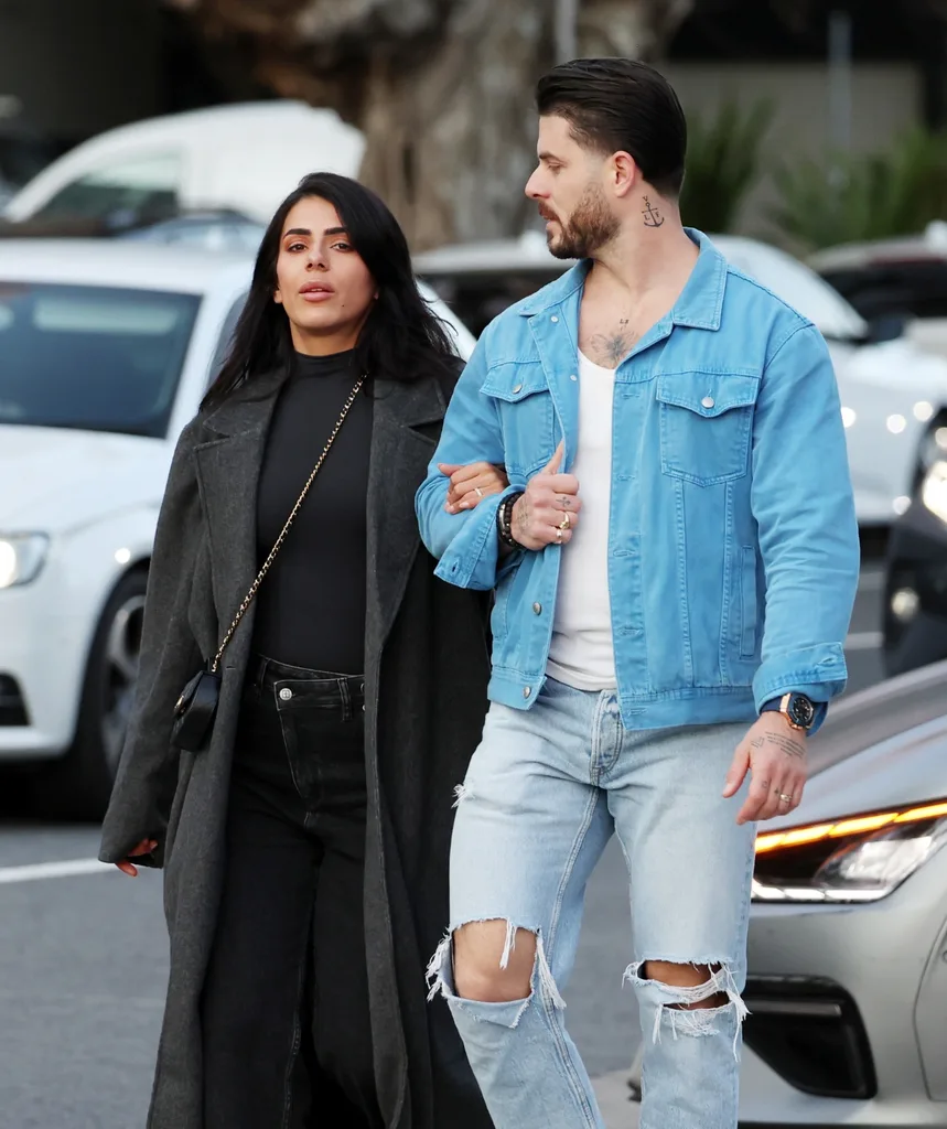 Carina and Paul walk arm in arm through the streets.
