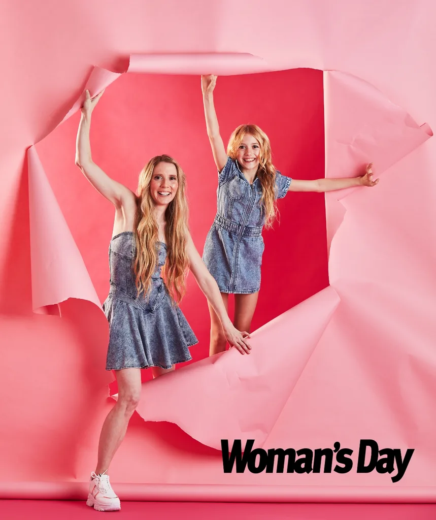 Nikki and Skylah jump out of pink ripped paper on set