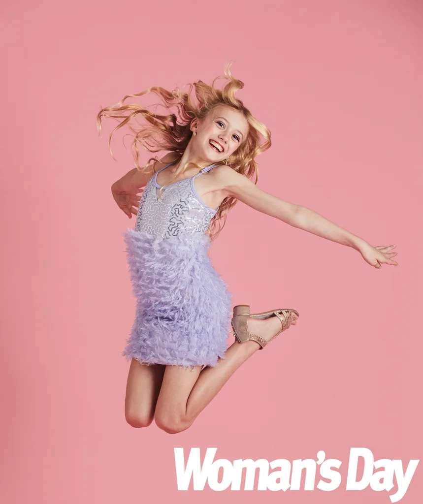 Skylah jumps through the air in a purple dress.