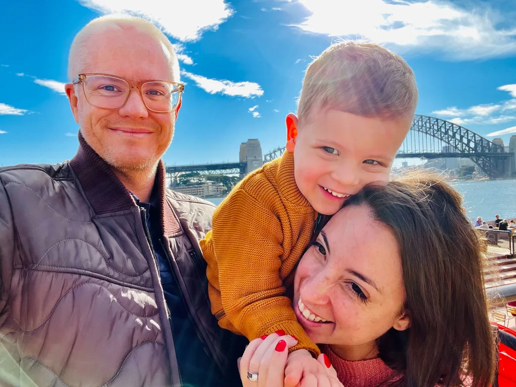 Jade, Daniel and Jordan cuddling in front of Sydney Harbour Bridge