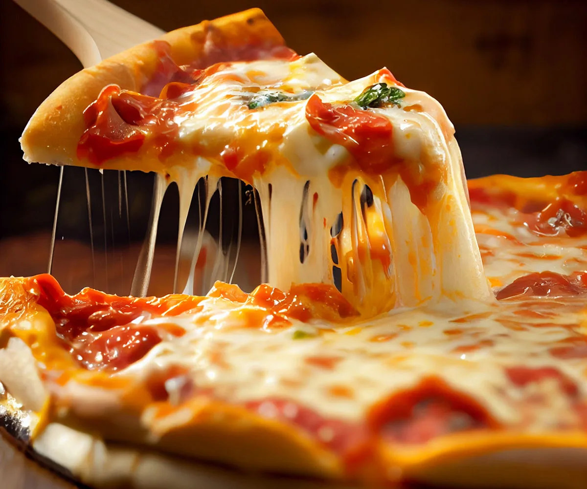 Cheat's pizza! Make your own with store-bought pita bread, sliced tomato, basil, ham or bacon and grated mozzarella. (Image: AdobeStock)