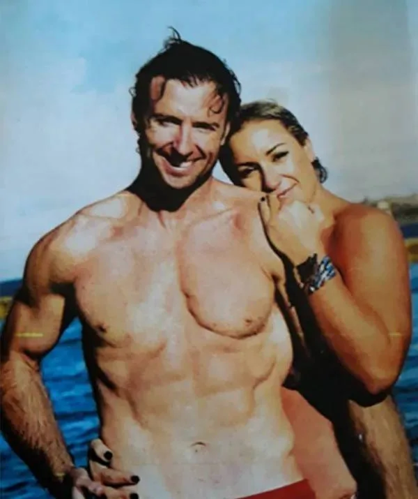 A man and woman smiling, wearing their swimmers.