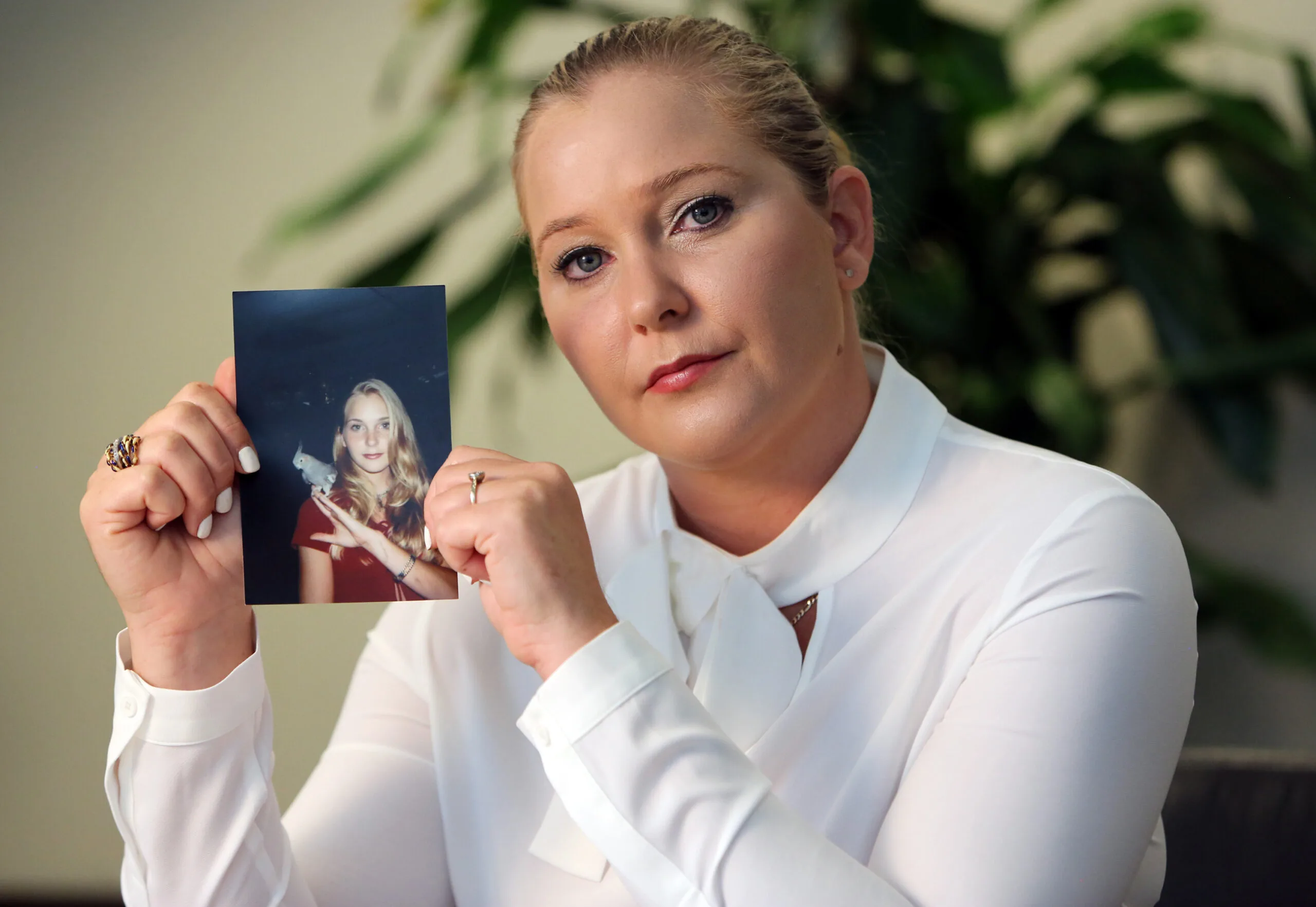 Virginia holds up a photo of herself as a teenager.
