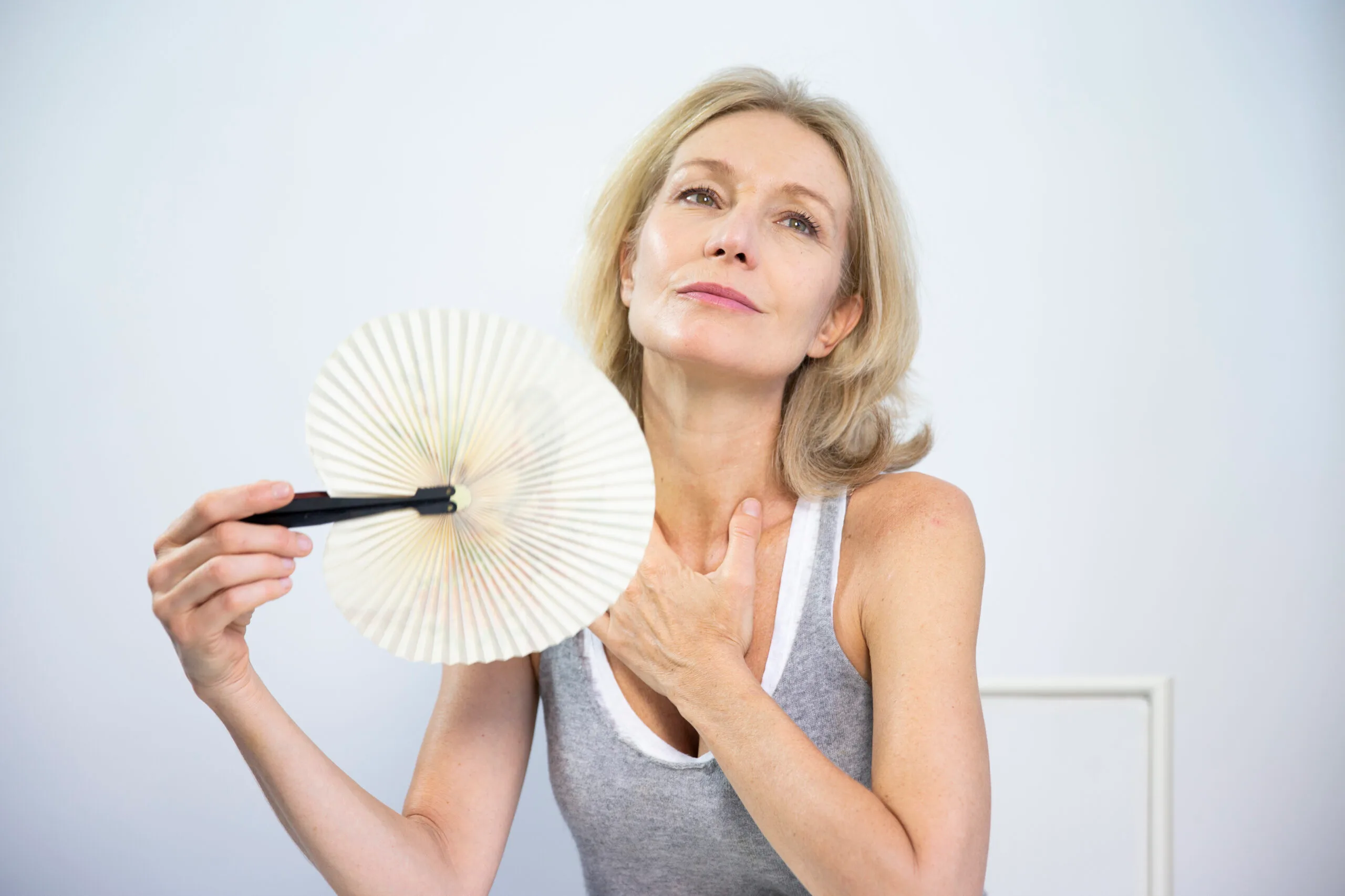 Woman fanning face to relieve hot flush