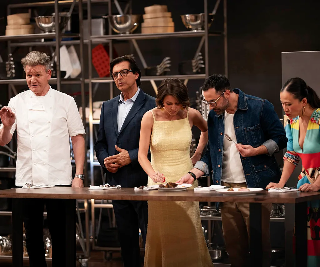 Gordon on the left giving feedback to a contestant after he has just tasted a dish. To his right are his fellow judges Jean-Christophe, Sofia, Andy and Poh