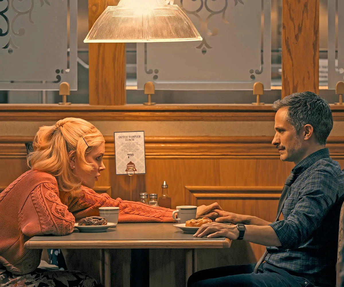 NICOLE KIDMAN and GAEL GARC&Iacute;A pictured in Holland sitting at a table in a cafe, Nicole leans across the table to hold his hand while wearing an orange jumper. There are coffee mugs and pastries on the table.