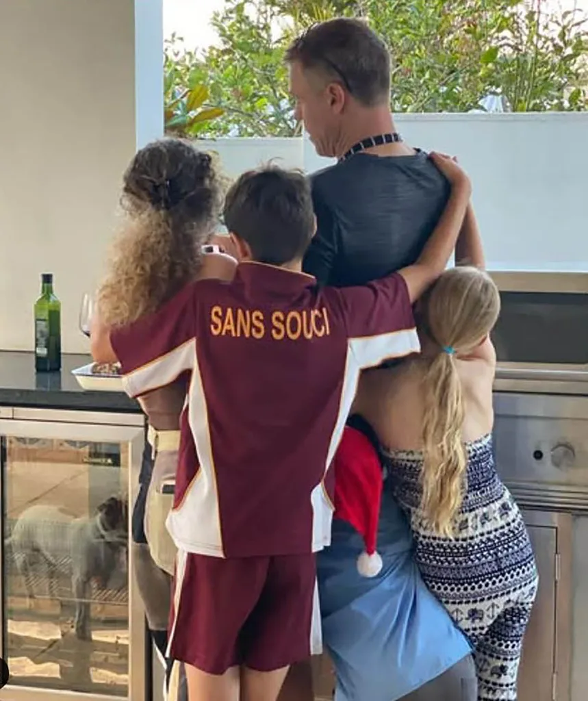 Rodger's kids huddle around him on a back patio as they share a group hug