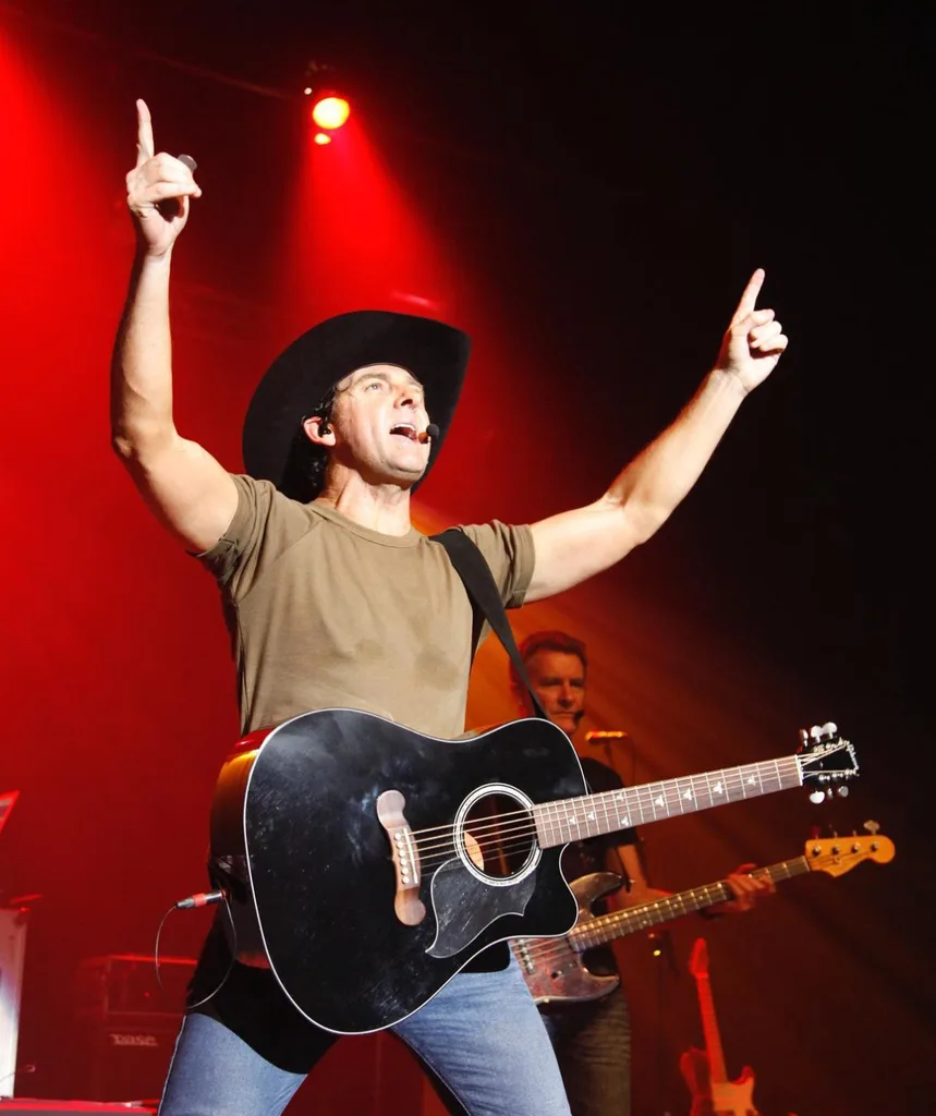 Lee performs with an acoustic guitar at a gig.