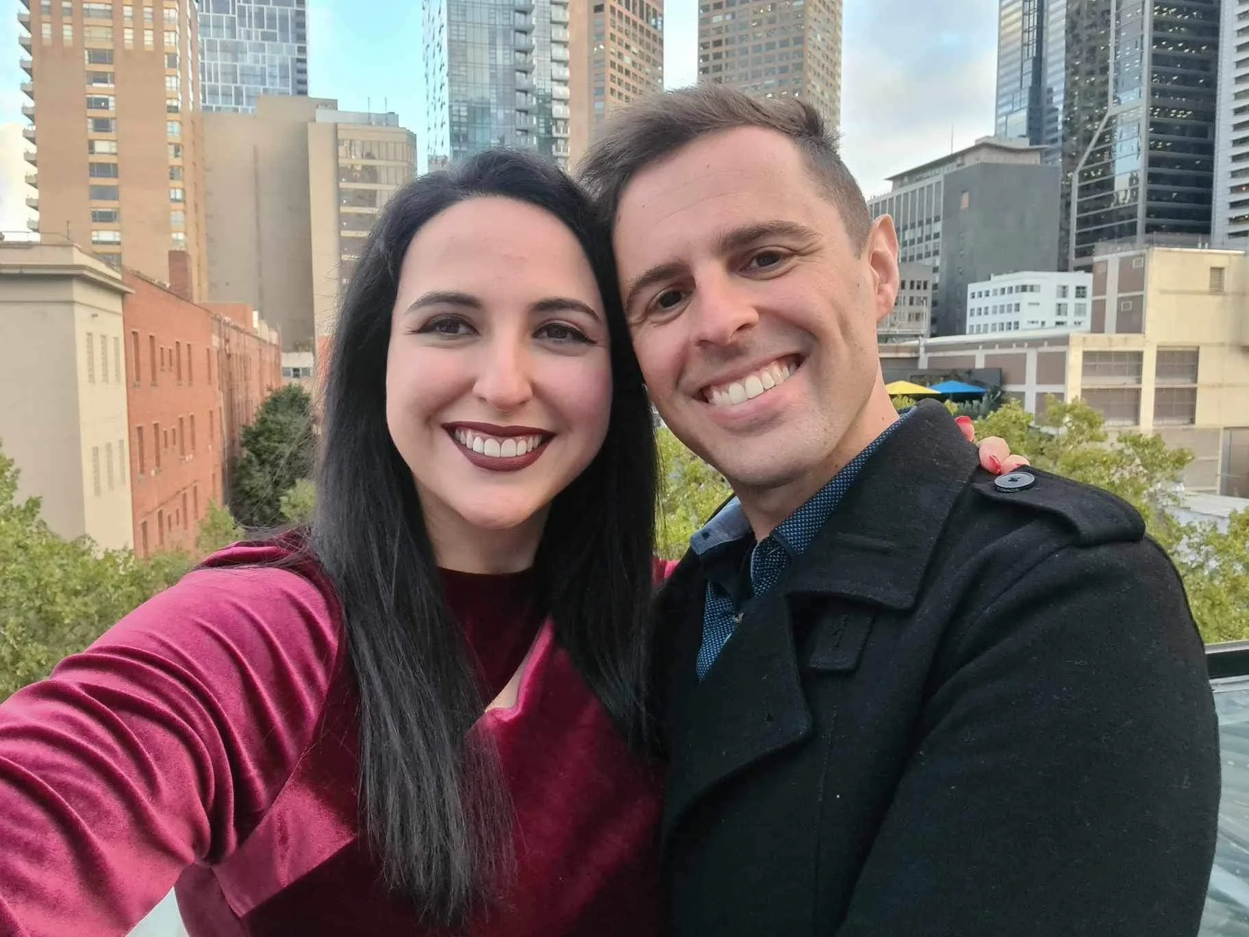 Elinor and Daniel on a rooftop with tall buildings behind them