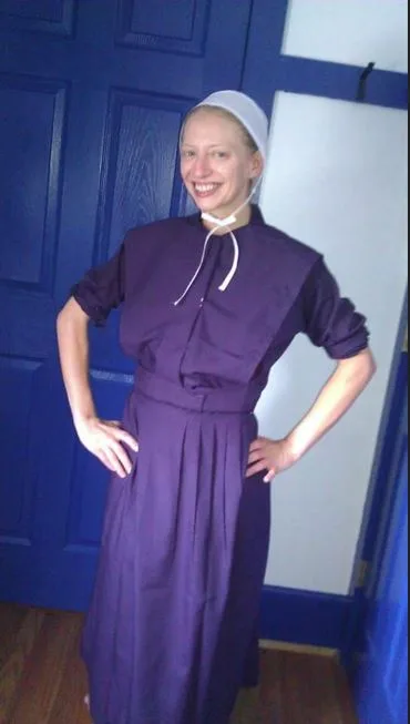 Naomi in a traditional Amish outfit, wearing a bonnet and a modest dress. 