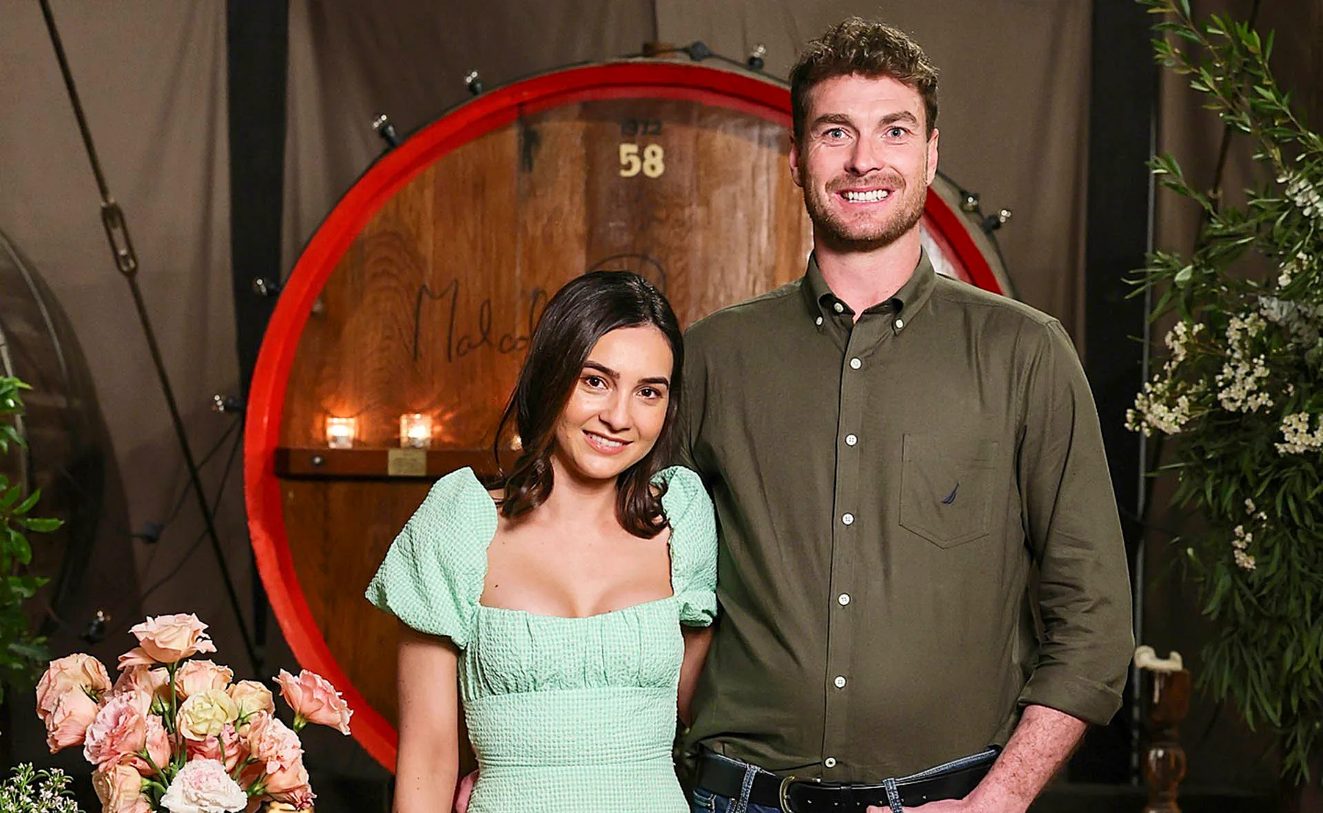 Thomas and Claire stand next to each other in the barrel room at the speed dating event. 
