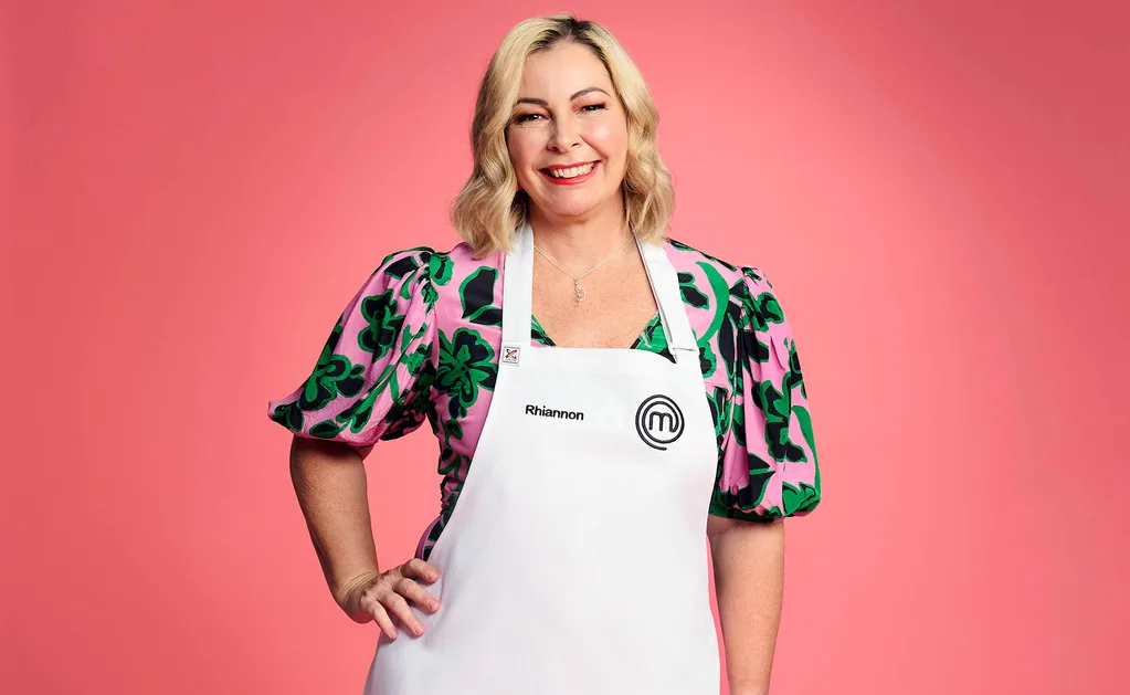 Rhiannon poses in her MasterChef Australia apron, hand on hip, smiling.