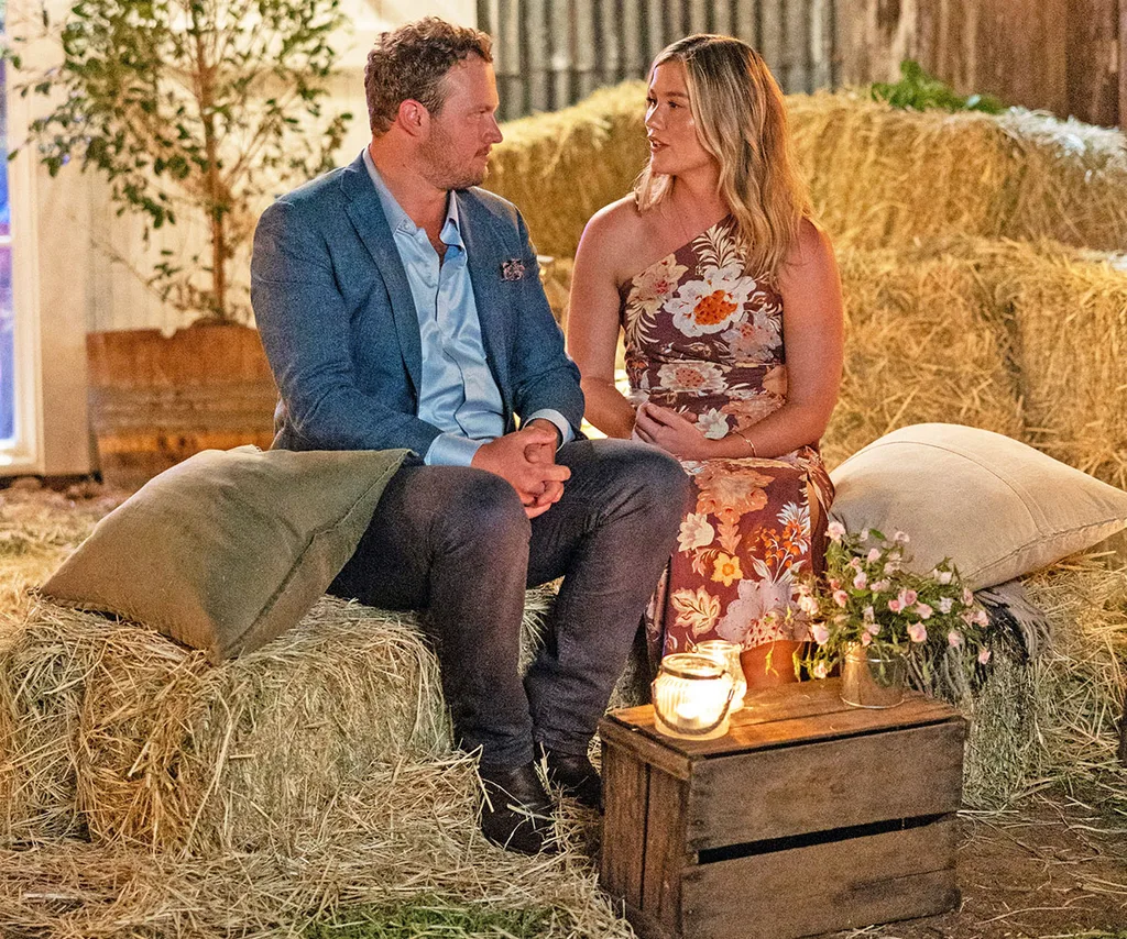 Corey and Chloe look into each other's eyes while sitting on haybales at the country ball.