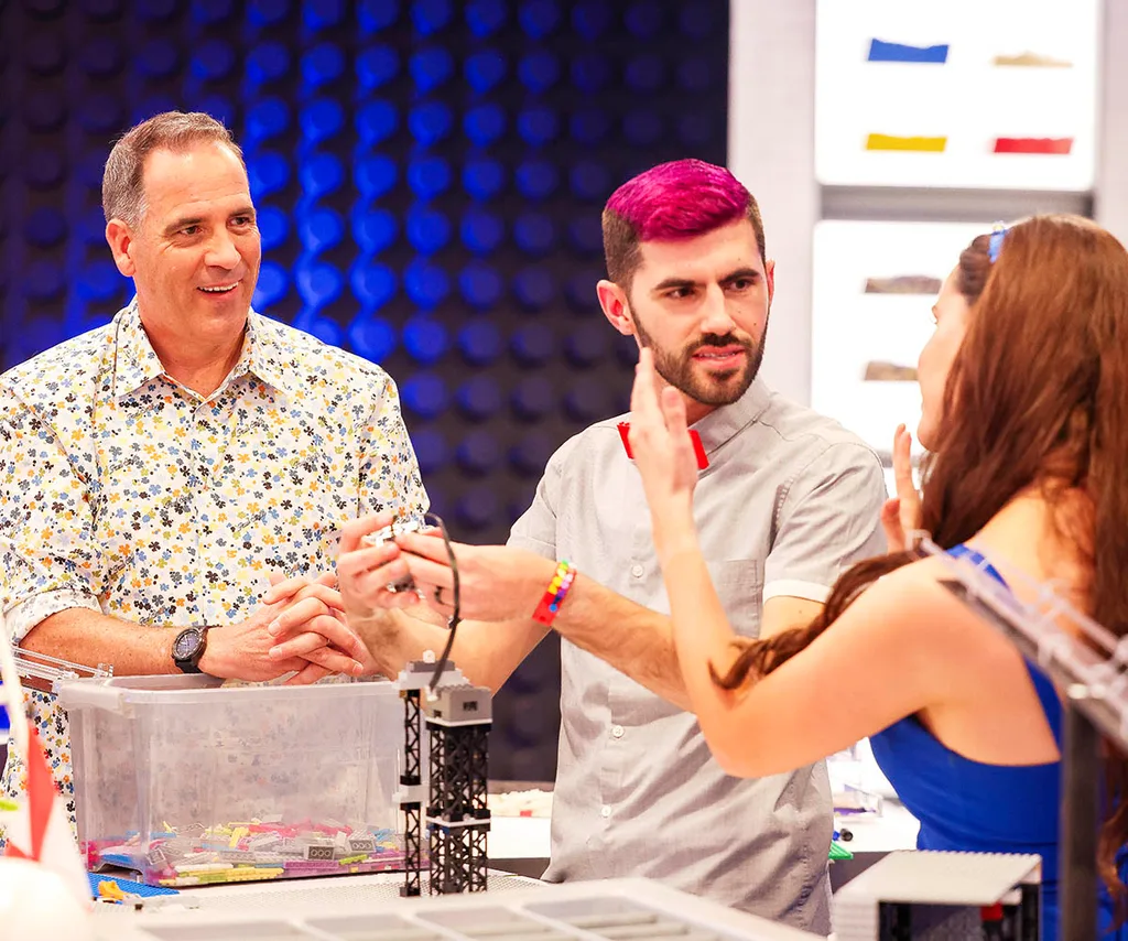 Brickman chats to two contestants on the set of LEGO Masters.