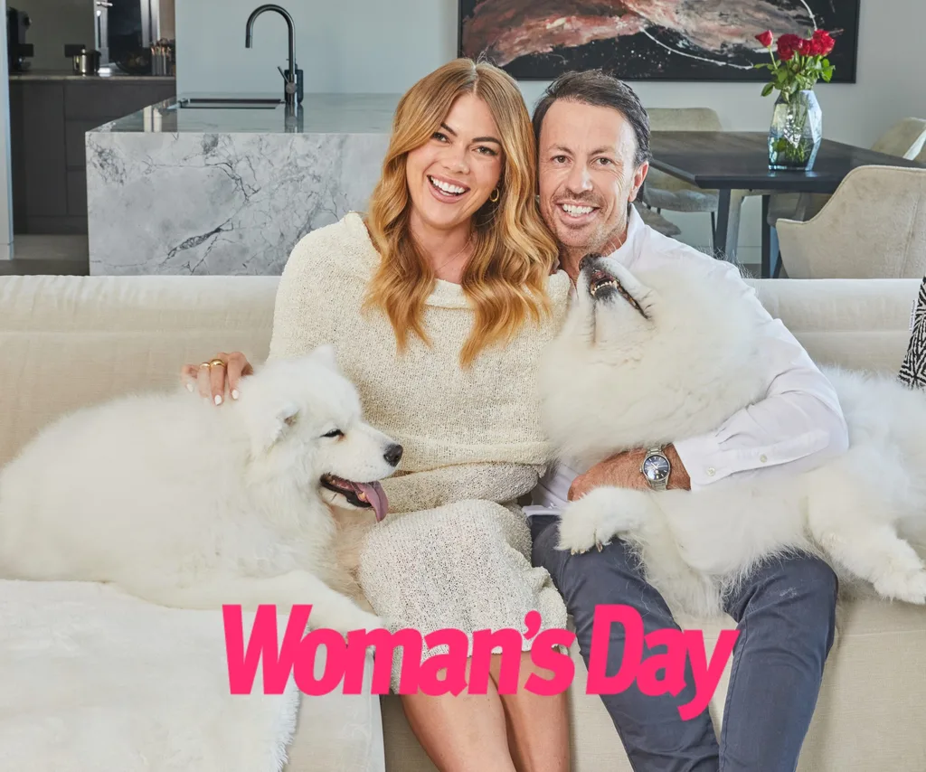 Jacqui and Clint pose together on the couch with his dogs.