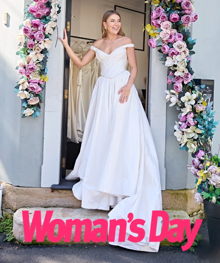Jacqui stands in the doorway of the Moira Hughes boutique in Sydney surrounded by flowers.