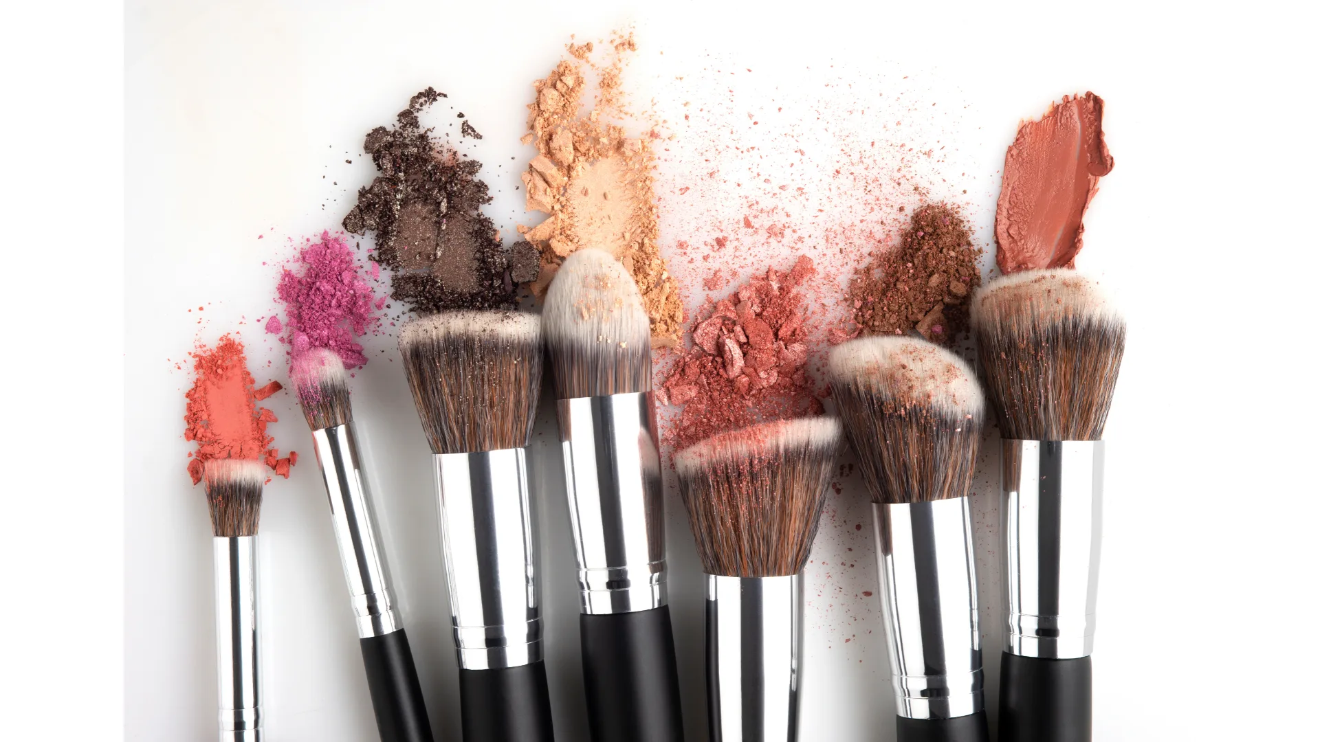 Makeup brushes caked with product sit side-by-side.
