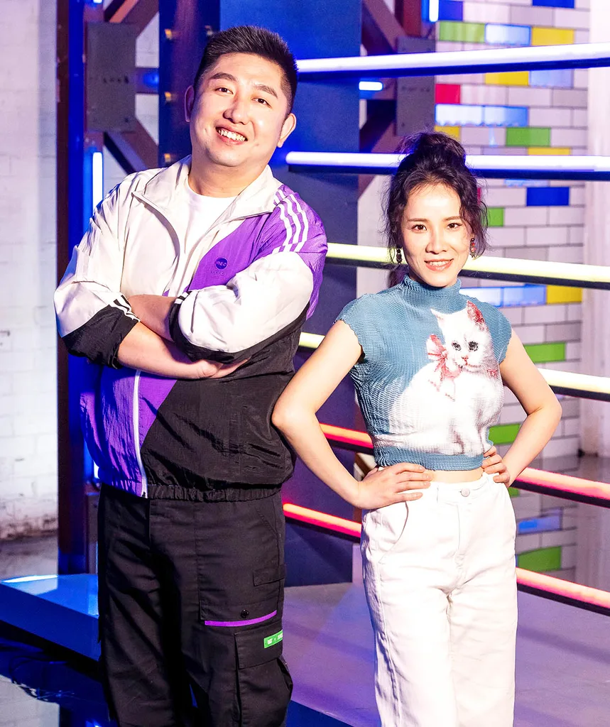 On left: Jiayuan, arms crossed, smiling in a purple white and black matching tracksuit
On right: Dai in white jeans, a blue top with a white kitten on it and her brown hair in a bum on the LM set