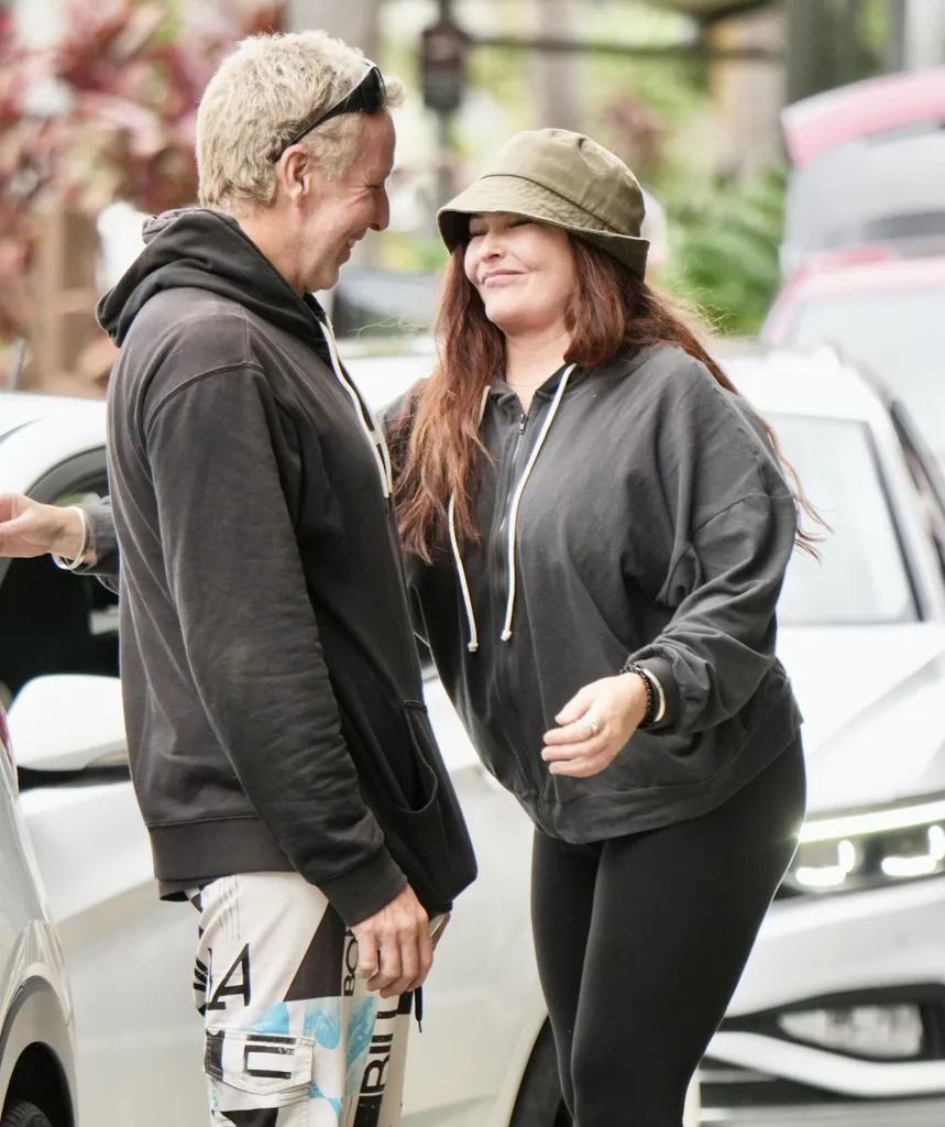 A man and woman face each other smiling.