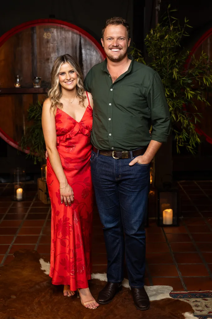Keeley, in a red dress, and Corey, in a green shirt, stand next to each other at the reunion.