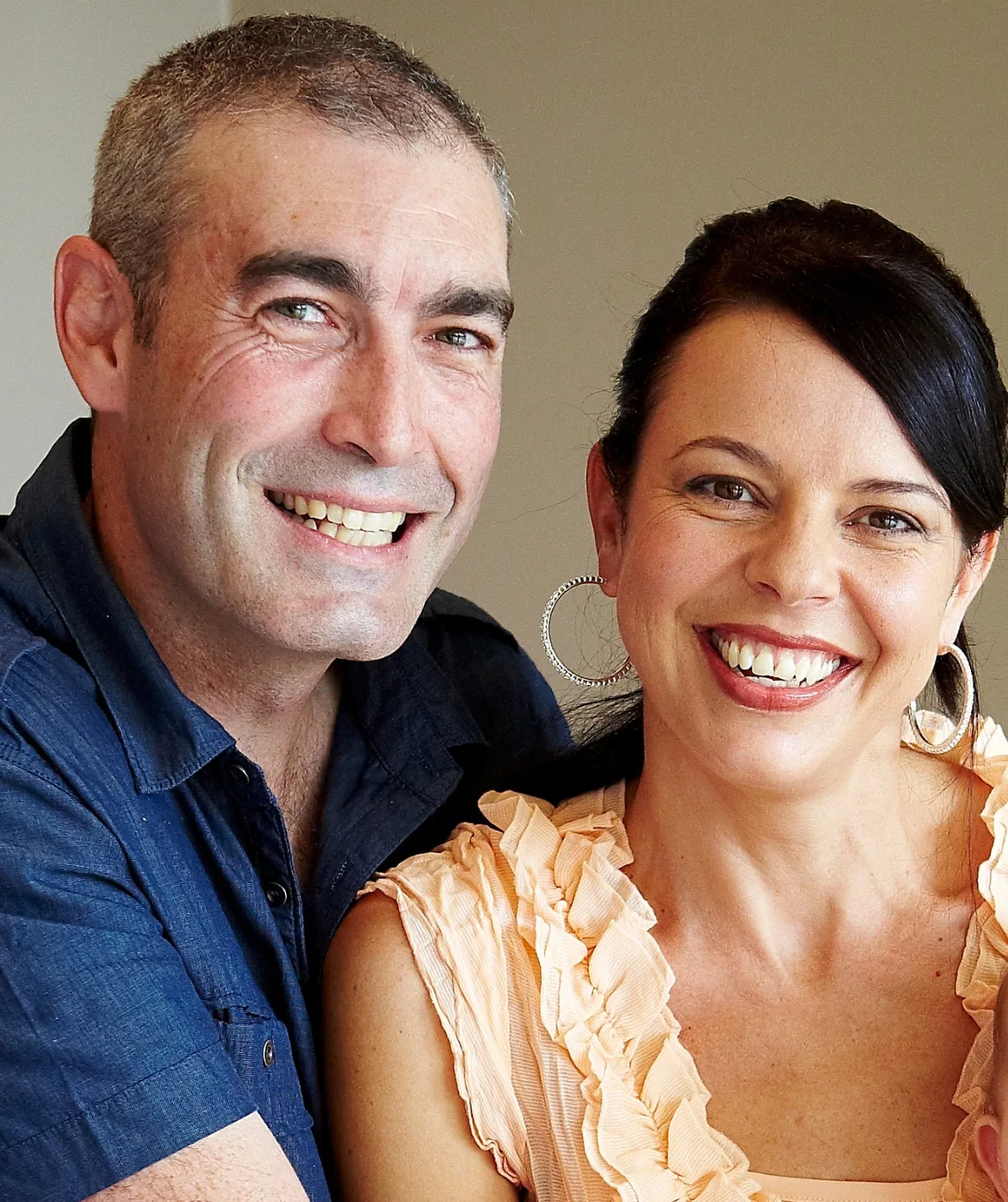 A man and woman smile at the camera