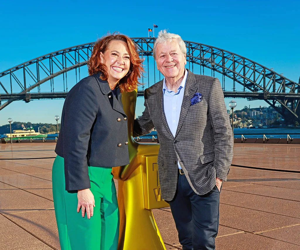 Lisa Millar and Ray Martin, standing either side of a giant Gold Logie, stand in front of the Sydney Harbour Bridge.