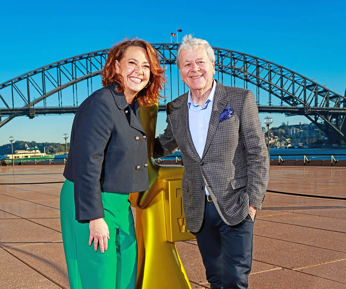Lisa Millar and Ray Martin, standing either side of a giant Gold Logie, stand in front of the Sydney Harbour Bridge. 