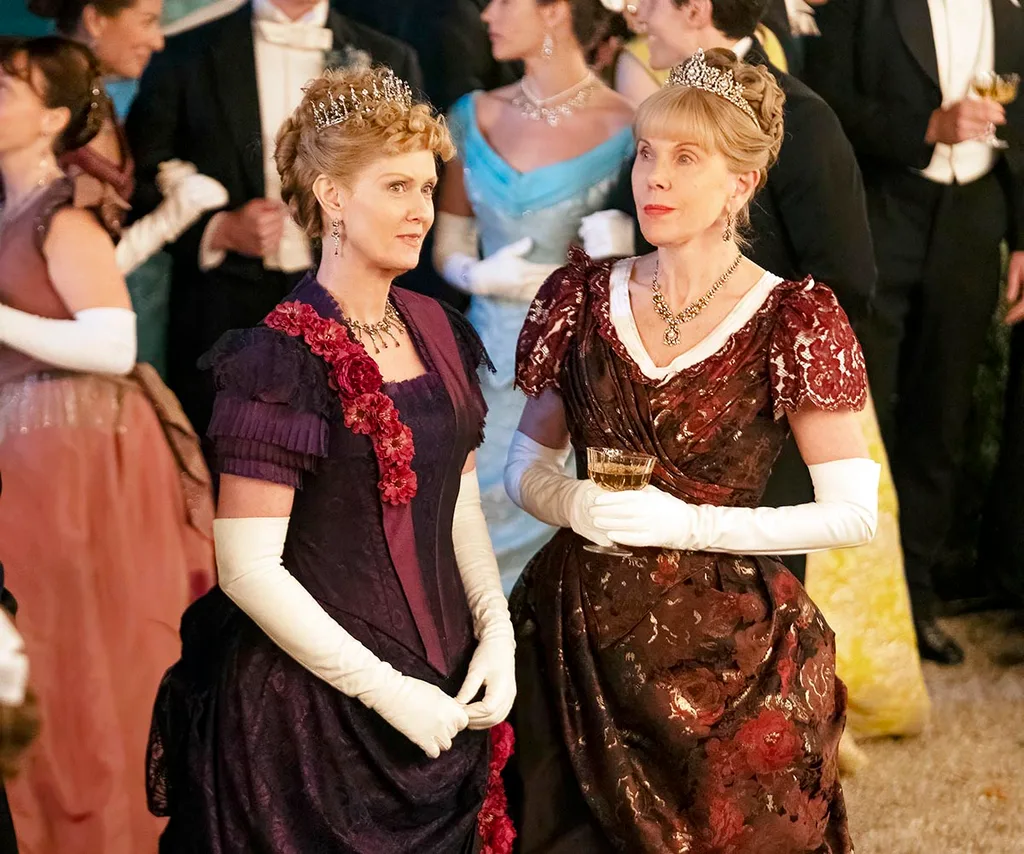 Ada and Agnes dressed in red gowns with white gloves.