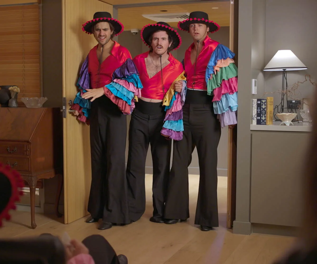 Jack, Dom and Liam wear sombreros  and Mexican styled colourful outfits as they stand in a doorway looking shocked