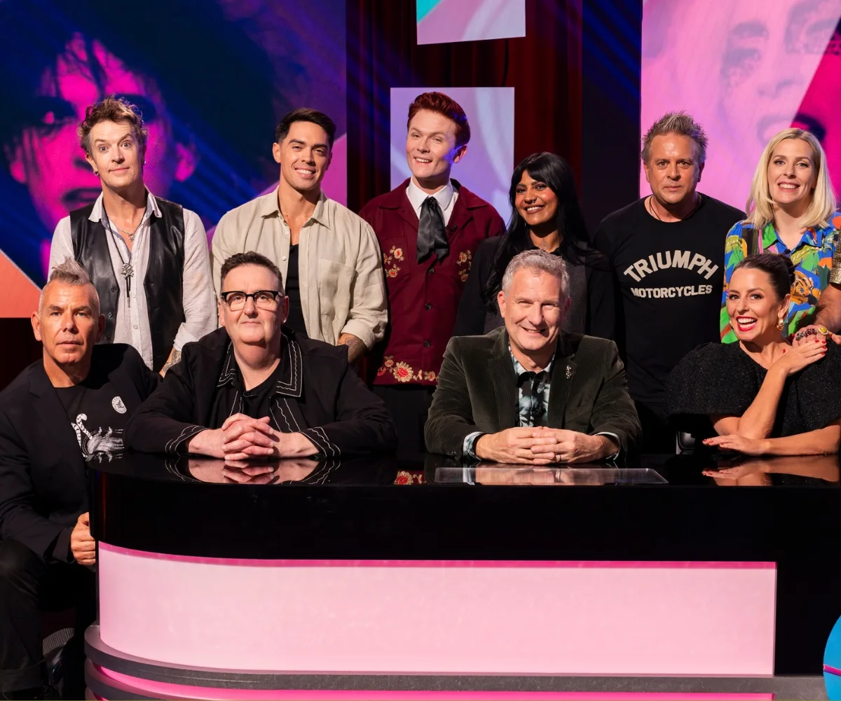 A group of people pose behind a desk.