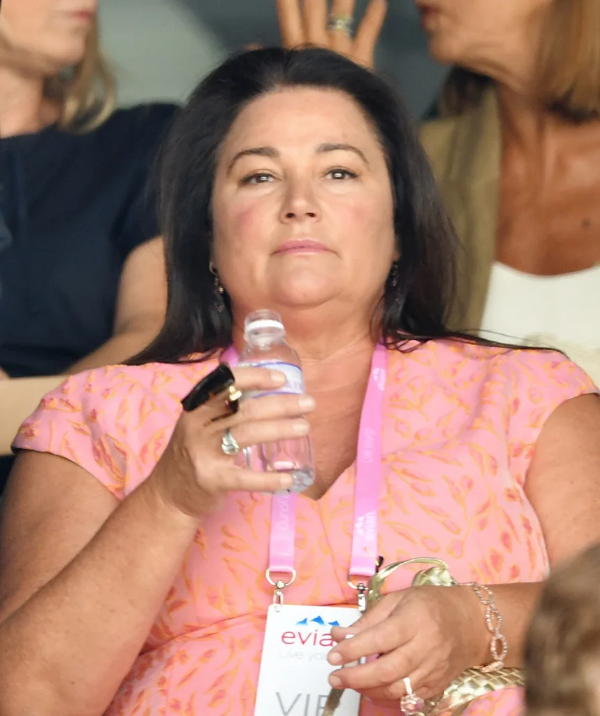 Keely sits in a crowd holding a water bottle.
