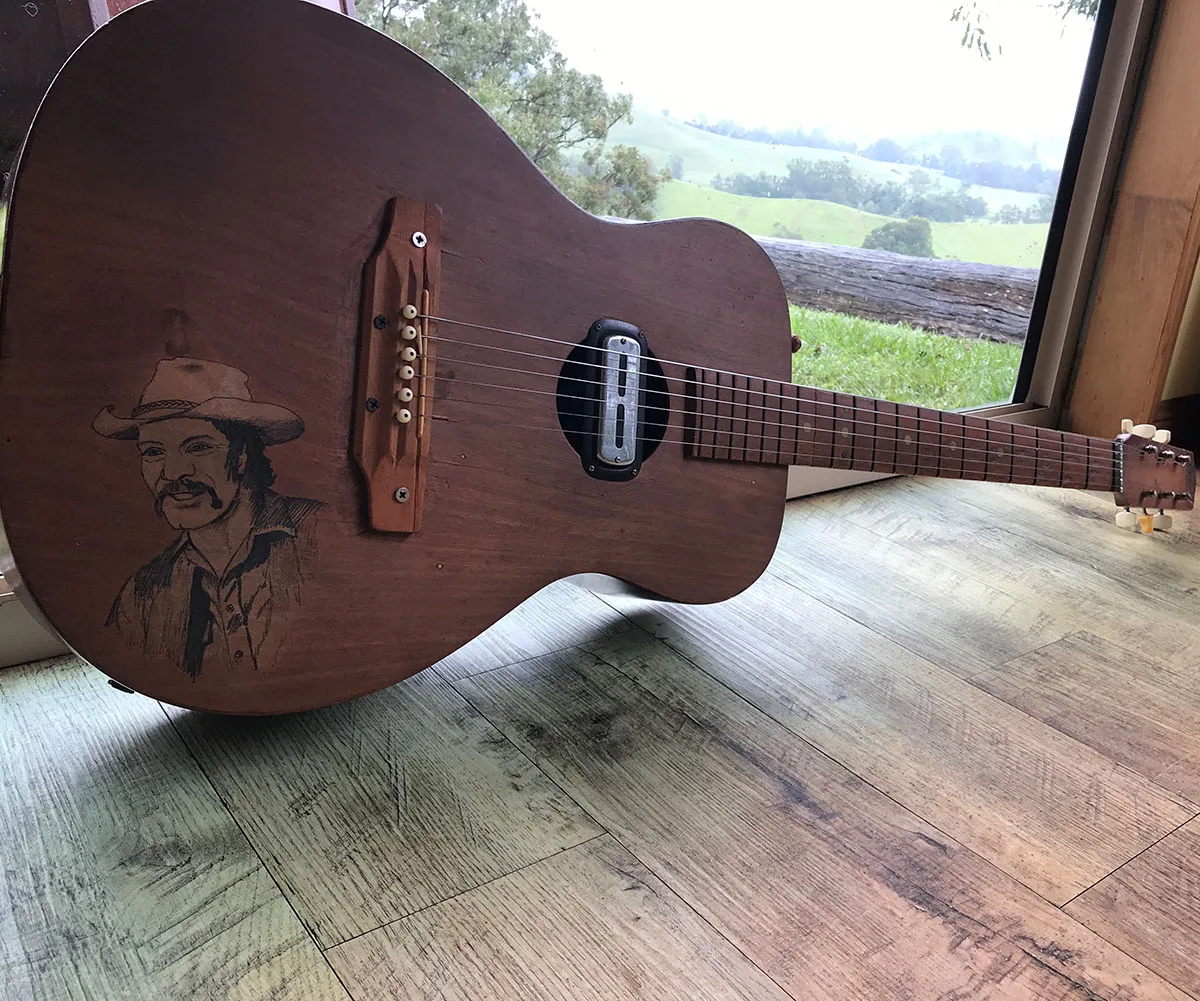 Dad's guitar with his self portrait on it. (Image: Supplied)