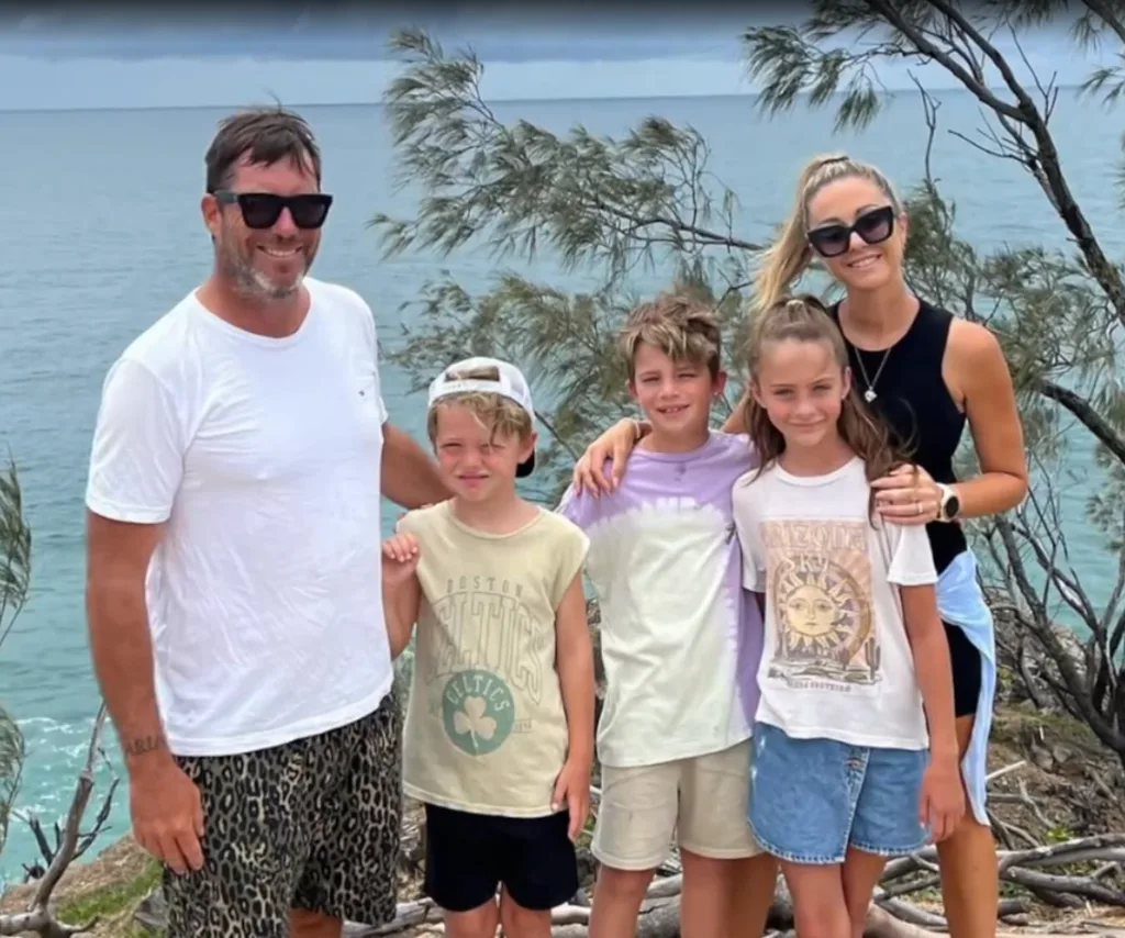 Sonny and Alicia from The Block 2025 pictured with their three kids in front of the ocean smiling.