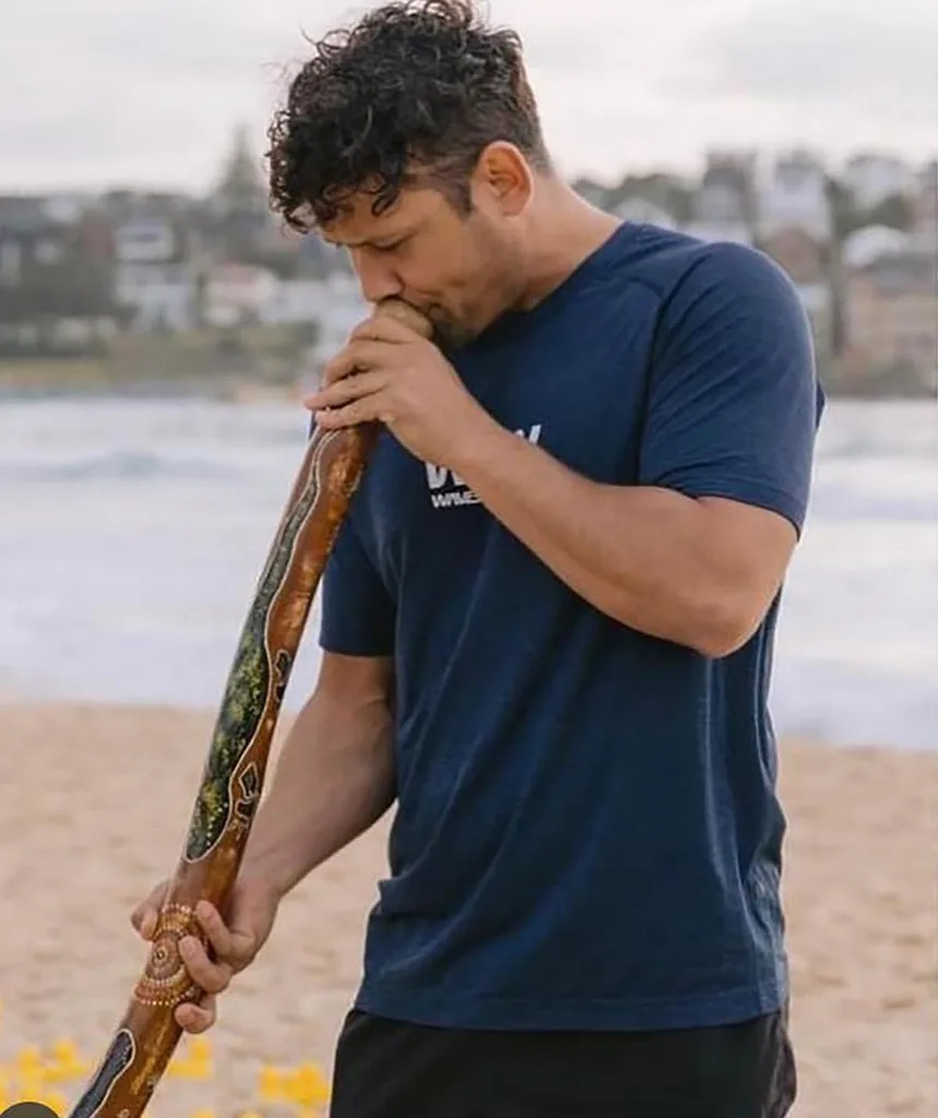 Kyle Shilling, in a dark blue t-shirt, on a beach.